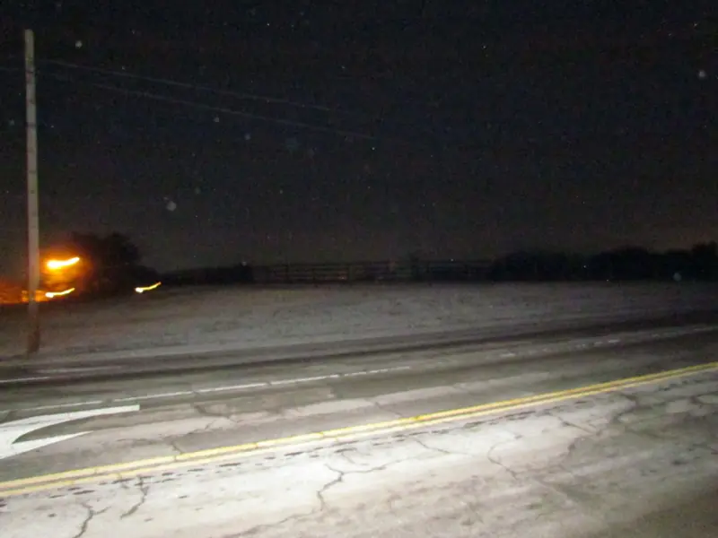 An empty road at night beside a field